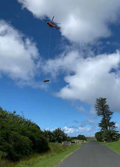 Helicopter in the sky with a winch hanging below it