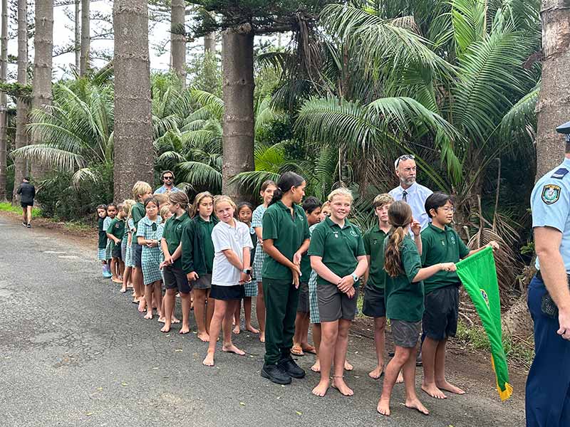 A group of school children gathers on Anzac Day for the commemoration ceremony held at the Lord Howe Island Cenotaph.