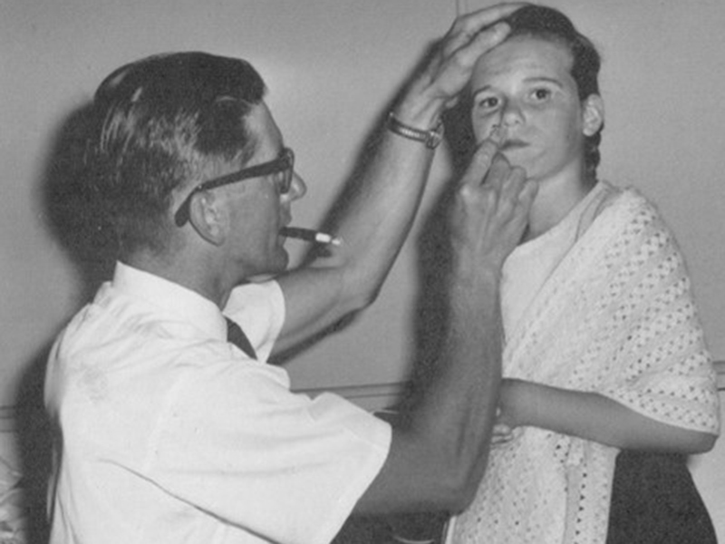 David Murray applying grease paint make-up to Heather Missen prior to a school concert