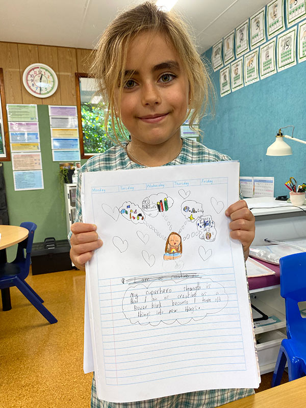 A photo of a Lord Howe Island student showing her superhero strength artwork.