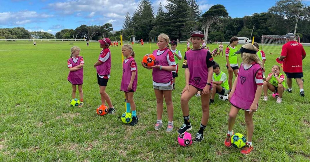 A group of kids lined up with soccer balls ready to learn some new skills at the recent Lord Howe Island Soccer camp.