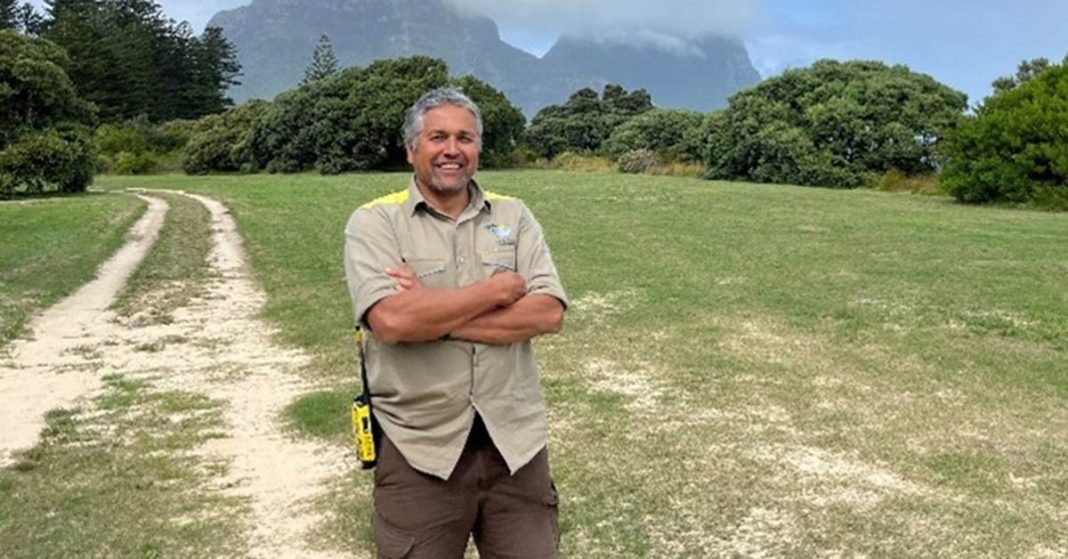 An image of new Team Leader Darryl Birch standing outside with mountain backdrop.