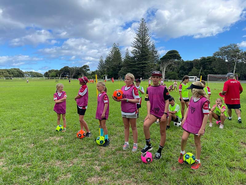 A group of kids lined up with soccer balls ready to learn some new skills at the recent Lord Howe Island Soccer camp.