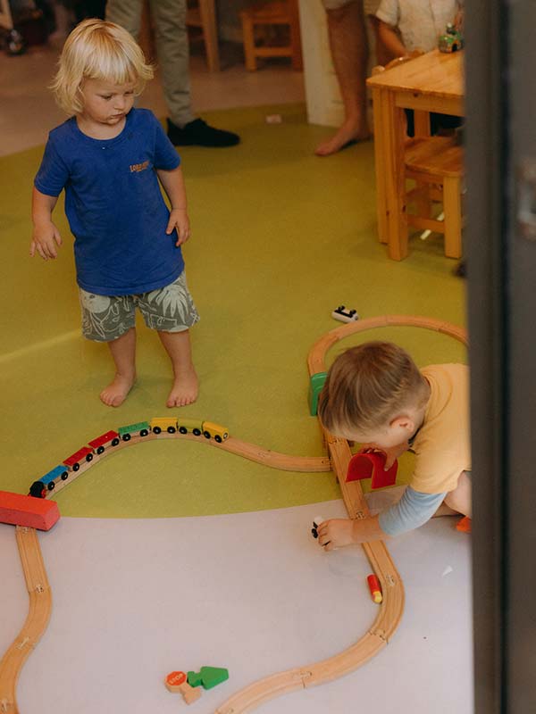 The opening of the new Lord Howe Island Preschool, two little boys are playing together with a wooden train on a wooden train track.