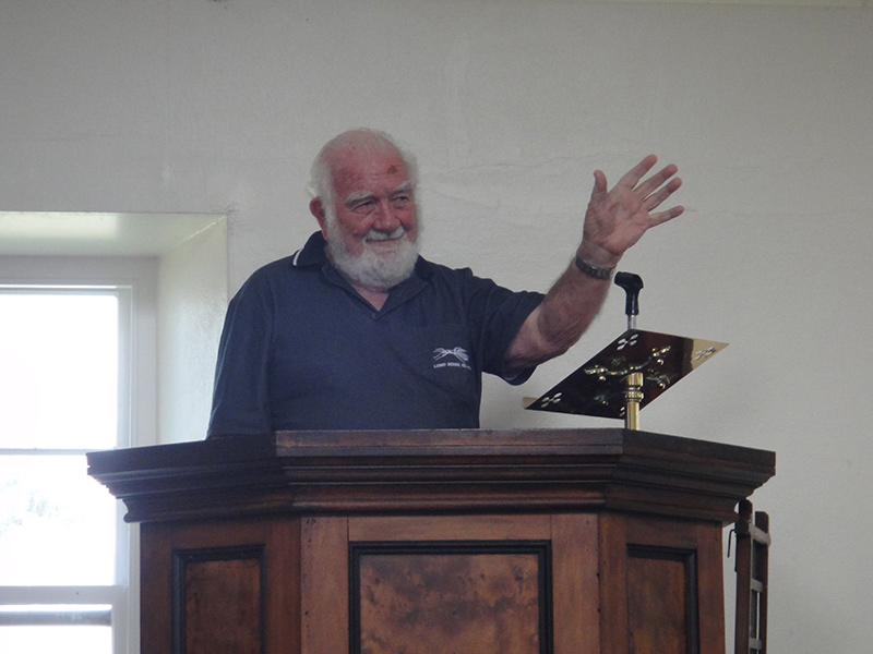 A photo of Esven Fenton giving his listeners a benediction from the lectern/pulpit