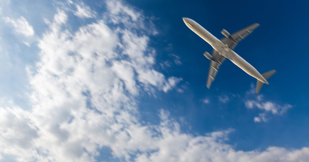 A plane flying in the sky surrounded by clouds