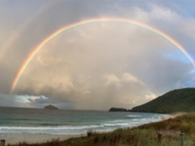 A rainbow over the mountain and ocean