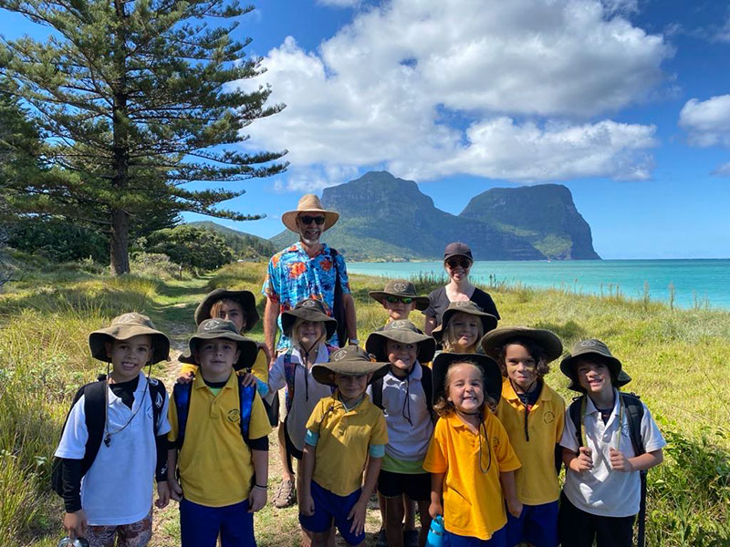 An image of Lord Howe Island school students making their way to school barefoot